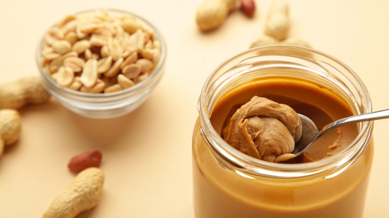 Peanuts next to peanut butter